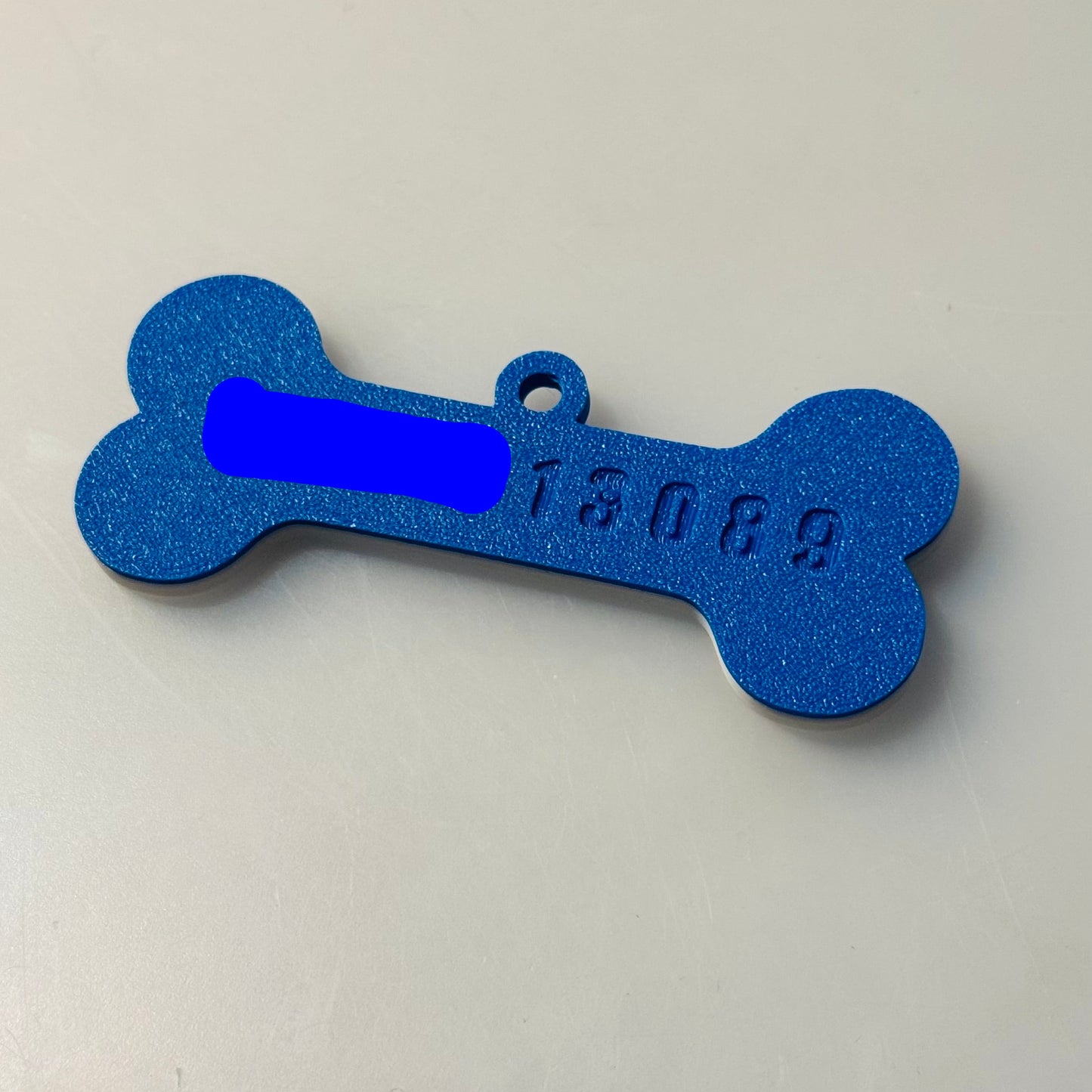 Blue bone-shaped tag with text on a light gray background
