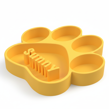 Yellow paw-shaped dog bowl with 'Sunny' text on a white background