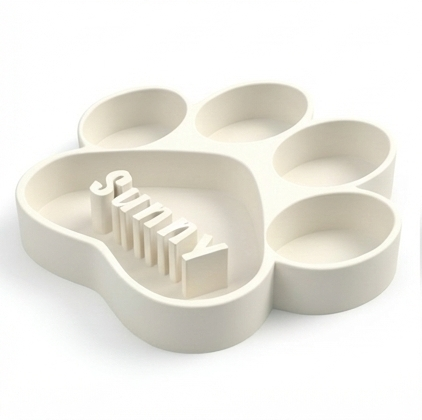 White paw-shaped dog bowl with 'Sunny' text on a white background