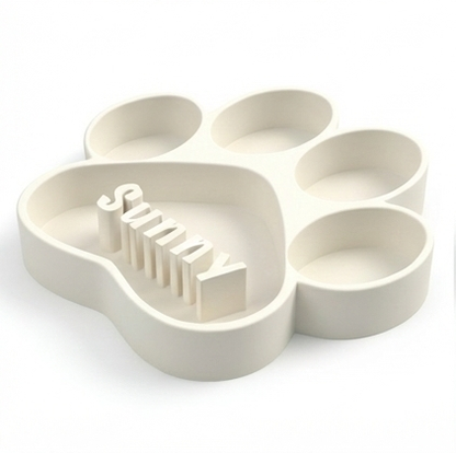 White paw-shaped dog bowl with 'Sunny' text on a white background