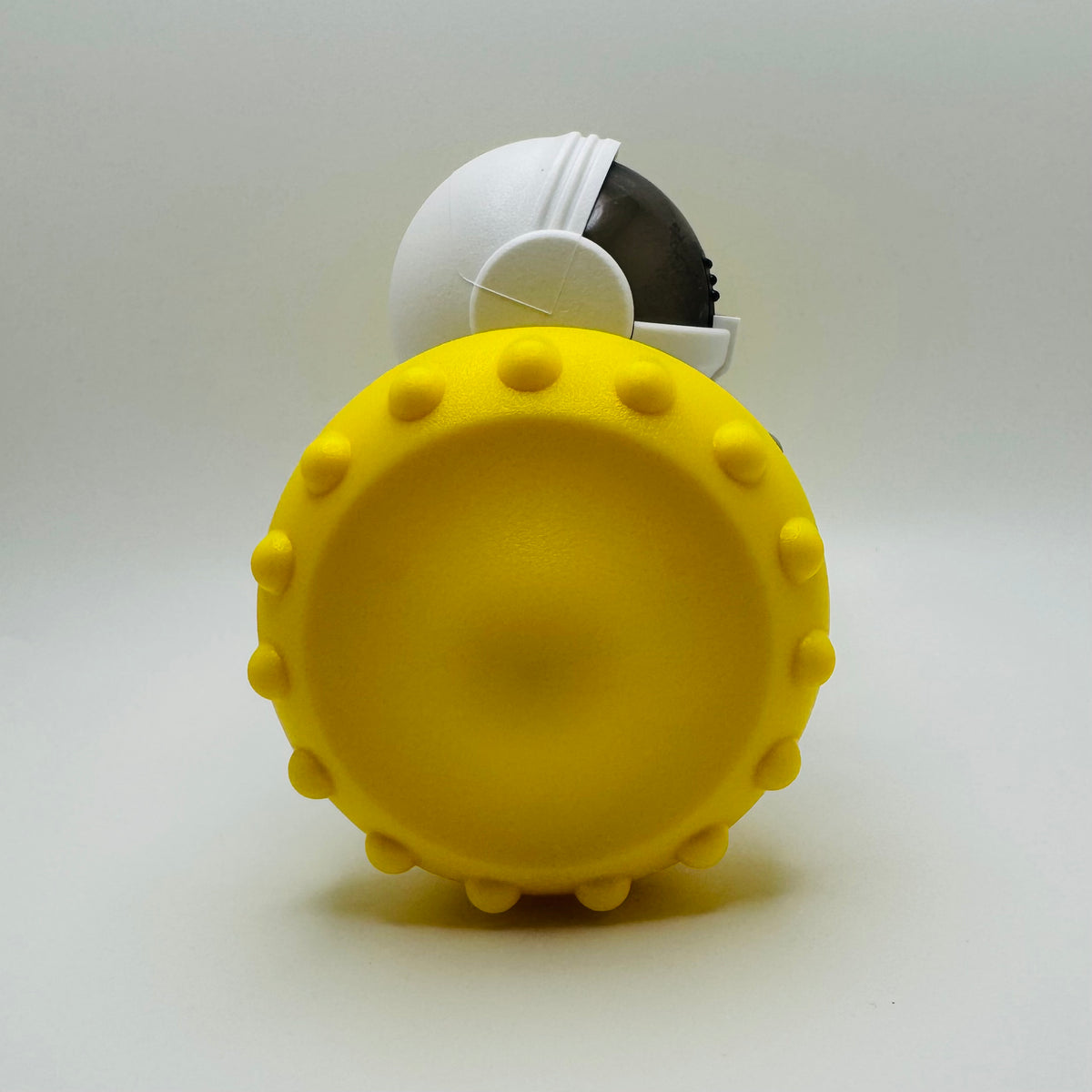 Yellow Robot Slow Feeder & Treat Dispenser Toy, side view of the spiked wheel