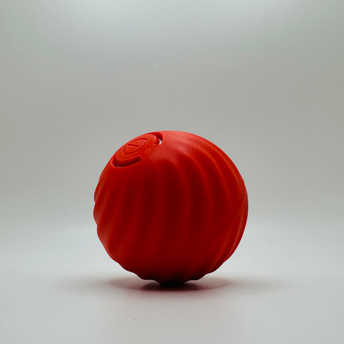 Red USB Vibrating Ball Toy for dogs and cats, side view of the textured shell