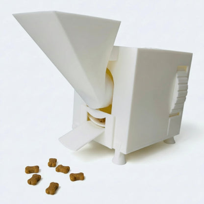 White interactive pet food dispenser with scattered kibble on a white background