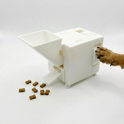White interactive pet food dispenser with scattered kibble on a white background